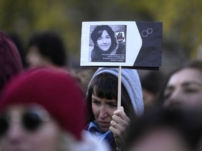 A woman shows a photo of Giulia Cecchettin, allegedly killed by ex-boyfriend, on the occasion of International Day for the Elimination of Violence against Women, in Milan, Italy, Saturday, Nov.25, 2023. Thousands of people are expected to take the streets in Rome and other major Italian cities as part of what organizers call a "revolution" under way in Italians' approach to violence against women, a few days after the horrifying killing of Giulia, the college student allegedly by her resentful ex-boyfriend sparked an outcry over the country's "patriarchal" culture.