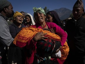 A woman holds the lifeless body of her grandchild killed in an earthquake in Jajarkot district, Nepal, Sunday, Nov. 5, 2023.