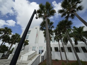 FILE - A police officer stands beside an entrance to the Alto Lee Adams Sr. U.S. Courthouse, Aug. 15, 2023, in Fort Pierce, Fla. A federal judge in Florida has indicated she may delay the start of former President Donald Trump's trial on charges that he hid classified documents at Mar-a-Lago. U.S. District Judge Aileen Cannon questioned prosecutors Wednesday about whether starting the trial in May as scheduled is feasible.