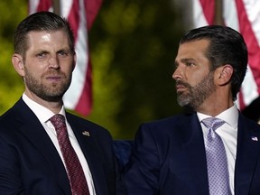 Eric Trump and Donald Trump Jr., wait for President Donald Trump to speak from the South Lawn of the White House, Aug. 27, 2020, in Washington.