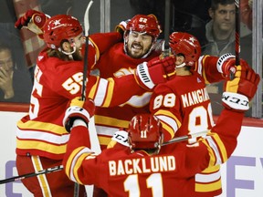 Calgary Flames defenceman MacKenzie Weegar, centre, celebrates his goal with teammates during overtime against the Vegas Golden Knights.