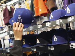 A customer picks up a Los Angeles Dodgers cap after the signing of Shohei Ohtani.