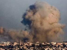 A smoke plume erupts over Khan Yunis from Rafah in the southern Gaza strip during Israeli bombardment on December 26, 2023, amid continuing battles between Israel and the Palestinian Hamas militant group.