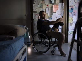 Israeli soldier Jonathan Ben Hamou, 22, wounded in the war with Hamas, sits in his room at Sheba hospital's rehabilitation division, in Ramat Gan, Israel, Monday, Dec. 18, 2023.