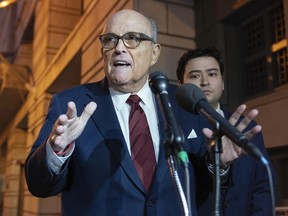 Former New York Mayor Rudy Giuliani talks to reporters as he leaves the federal courthouse in Washington, Monday, Dec. 11, 2023.