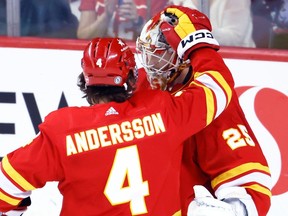 Calgary Flames goalie Jacob Markstrom, right, celebrates with teammate Rasmus Andersson the team's 3-1 victory over the Florida Panthers after NHL hockey action in Calgary, Alta., Monday, Dec. 18, 2023.