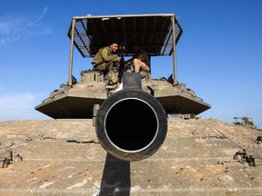 Israeli troops and military vehicles are positioned near the border with the Gaza Strip on December 3, 2023.