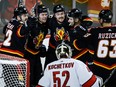 Carolina Hurricanes goalie Pyotr Kochetkov (52) looks on as Calgary Flames forward Connor Zary (47) celebrates his goal with teammates during third period NHL hockey action in Calgary