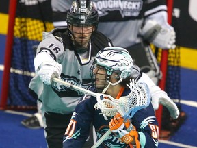 The Calgary Roughnecks’ Seth Van Schepen guards the New York Riptide’s Jeff Teat on WestJet Field at Scotiabank Saddledome in Calgary on Feb. 2, 2024. The Riptide won 11-10.