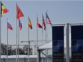 This photograph taken on February 27, 2024 shows an empty mast amongst member nation flags in the Cour d'Honneur of the NATO headquarters, ahead of a flag-raising ceremony for Sweden's accession to NATO, in Brussels on February 27, 2024.
