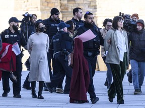 Pro-Palestine protesters who disrupted question period in the House of Commons are led away by Parliamentary Protective Service officers outside West Block on Parliament Hill in Ottawa, Wednesday, Feb. 14, 2024.