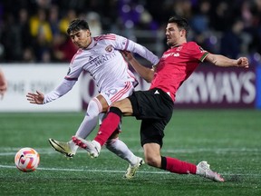 Orlando City’s Facundo Torres, left, takes a shot on goal as Cavalry FC’s Charlie Trafford defends during their Concacaf Champions Cup match at Starlight Stadium in Langford, B.C., on Wednesday, Feb. 21, 2024.