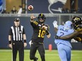 Hamilton Tiger-Cats quarterback Matt Shiltz (18) throws a pass while under pressure by Toronto Argonauts defensive lineman Folarin Orimolade (7) during second half CFL action in Toronto, on Sunday, June 18, 2023. Shiltz signed a one-year deal this month with Calgary.THE CANADIAN PRESS/Christopher Katsarov