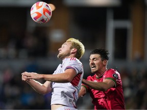 Orlando City's Duncan McGuire, front left, and Cavalry FC's Charlie Trafford vie for the ball during the first half of a CONCACAF Champions Cup soccer match, in Langford, B.C., on Wednesday, February 21, 2024.