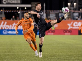 Cavalry FC defender Callum Montgomery tries to control the ball with Forge FC midfielder David Choiniere looking on during the Canadian Premier League final at Tim Hortons Field in Hamilton on Oct. 28, 2023.