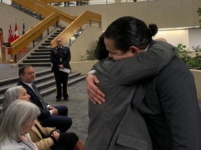 Manitoba Premier Wab Kinew hugs Assembly of Manitoba Chiefs Grand Chief Cathy Merrick at a press conference at RCMP headquarters in Winnipeg on Monday, Feb. 12, 2024. A 29-year-old Carman man has been charged with five counts of first-degree murder in the deaths of his common-law partner, three young children and the partner's 17-year-old niece on Sunday.