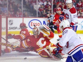 Calgary Flames goaltender Dustin Wolf blocks a shot from Montreal Canadiens forward Cole Caufield at the Scotiabank Saddledome in Calgary on Saturday, March 16, 2024.