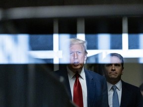 Former US President Donald Trump speaks to the press in a hallway outside the courtroom at the end of a hearing to determine the date of his trial for allegedly covering up hush money payments linked to extramarital affairs, at Manhattan Criminal Court in New York City on March 25, 2024.
