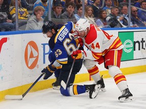 Jake Neighbours #63 of the St. Louis Blues battles Joel Hanley #44 of the Calgary Flames for control of the puck in the third period at Enterprise Center on March 28, 2024 in St Louis, Missouri. (Photo by Dilip Vishwanat/Getty Images)