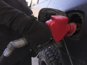 A driver pumps premium gas into her car at a gas station in Toronto on March 3, 2022.
