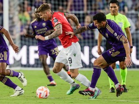 Cavalry FC forward Myer Bevan is pushed by Orlando City SC defender Kyle Smith during a Concacaf Champions Cup match at Inter&Co Stadium in Orlando, Fla., on Tuesday, Feb. 27, 2024.