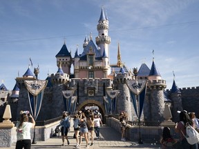 Visitors exit The Sleeping Beauty Castle at Disneyland in Anaheim, Calif. April 30, 2021.