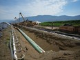 The Calgary Chamber of Commerce is warning the federal government that its proposed cap on emissions from the oil and gas sector could compromise the valuation of the Trans Mountain pipeline. Workers position pipe during construction of the Trans Mountain pipeline expansion in Abbotsford, B.C., on Wednesday, May 3, 2023.