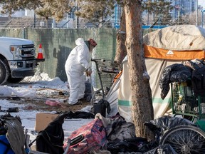 City workers remove items from an encampment near 95 Street and 106 avenue on Friday, Jan. 19, 2024 in Edmonton.