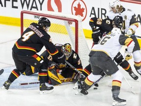 Calgary Flames goaltender Dustin Wolf moves to block a play by Vegas Golden Knights forward Pavel Dorofeyev at the Scotiabank Saddledome in Calgary on Thursday, March 14, 2024.