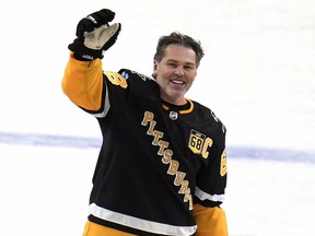 Former Pittsburgh Penguins player Jaromir Jagr waves to fans after skating during warm ups after having a banner with his retired uniform number raised to the rafters of PPG Paints arena before an NHL hockey game between the Los Angeles Kings and the Penguins in Pittsburgh, Sunday, Feb. 18, 2024.