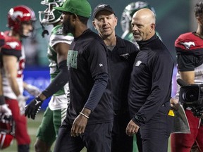 Calgary Stampeders head coach Dave Dickenson and brother Saskatchewan Roughriders head coach Craig Dickenson meet on the field after the game at Mosaic Stadium on Saturday, October 9, 2021 in Regina.
