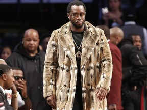Sean "Diddy" Combs, wearing a fur coat, walks down the sideline during the second half of an NBA basketball game between the Brooklyn Nets and the New York Knicks, Sunday, March 12, 2017, in New York.