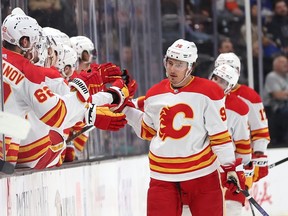 ANAHEIM, CALIFORNIA - APRIL 12: Andrei Kuzmenko #96 of the Calgary Flames is congratulated at the bench after scoring a goal during the second period of a game against the Anaheim Ducks at Honda Center on April 12, 2024 in Anaheim, California.