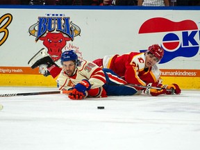 Calgary Wranglers rookie David Silye, in red, is tangled up with Bakersfield Condors star Seth Griffith during his American Hockey League debut. Silye, 25, joined the Wranglers after completing his collegiate career with the Wisconsin Badgers.