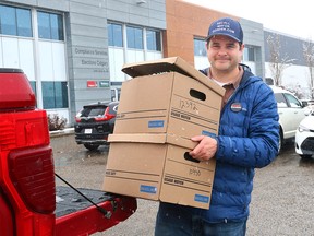 Landon Johnston with boxes of petition signatures to recall Mayor Jyoti Gondek at the Elections Calgary office
