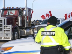 Authorities deal with a roadblock on Highway 4 and 501 outside Milk River heading towards the Coutts border on Thursday, Feb. 3, 2022.