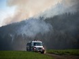 Firefighters drive across a farm while monitoring a controlled burn near a wildfire northwest of Vernon, B.C., Wednesday, Aug. 25, 2021.