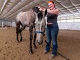 Equine practitioner Britain Mills-Dawes massages Tangerine Taxi's muscles at Grey Horse Farm on Monday, April 22, 2024 near Sherwood Park.