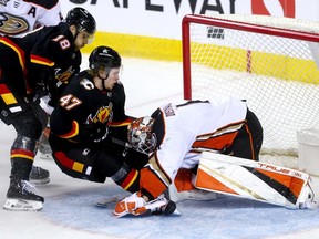 Calgary Flames forward Connor Zary collides with Anaheim Ducks goalie Lukas Dostal at the Scotiabank Saddledome in Calgary on Tuesday, April 2, 2024.