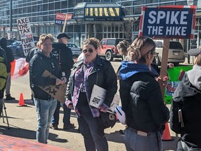 Demonstrators gather outside the office of Edmonton Centre Liberal MP Randy Boissonnault to protest the federal carbon tax on Monday, April 1, 2024.