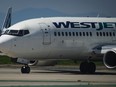 A WestJet Boeing 737-700 aircraft taxis to the runway for departure from Vancouver International Airport, in Richmond, B.C., on Friday, May 19, 2023. WestJet Encore pilots could go on strike as soon as April 17 after they approved a strike mandate Tuesday.