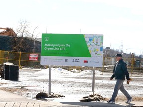 A pedestrian walks by as demolition and construction continues for the Green Line LRT at the site of the former Lilydale Chicken plant in the Ramsay neighbourhood in southeast Calgary on Tuesday, March 12, 2024.