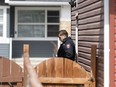 A police officer steps outside of a home on Redstone Common N.E. in Calgary, where a woman was killed on Sunday, April 21.