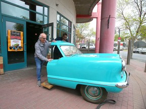 The Garage owner Charlie Mendelman and chef Robin Masih steady the front half of a 1960s Nash Metropolitan, to be loaded onto a truck.
