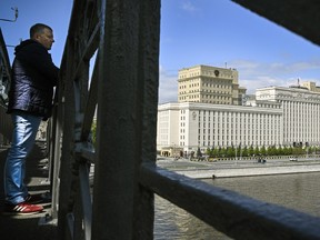 A man looks from a bridge across the Moskva river in front of the Russian Defence Ministry headquarters in Moscow on May 14, 2024.