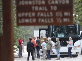 A tour bus loads up at the base of the Johnston Canyon trail in Banff National Park on May 17, 2016.