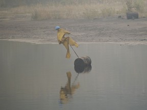 The Alberta government is appointing a new committee to look into ways to speed up the reclamation of the large growing tailings ponds in the province's oilsands. A scarecrow floats on the surface of a tailings pond to keep birds from landing in the toxic wastewater from oil production near Fort McMurray, Alta., Saturday, Sep. 2, 2023.