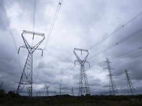 Power lines are seen against cloudy skies near Kingston, Ont. , Wednesday, Sept. 7, 2022 in Ottawa. The Alberta Utilities Commission is fining another power plant in the province for operating without a licence.