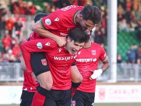 Cavalry FC’s Charlie Trafford jumps on Tobias Warschewski as they celebrate Warschewski’s second-half goal against Vancouver FC on ATCO Field at Spruce Meadows on Friday, May 3, 2024