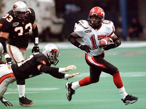 Calgary Stampeders' center back Marvin Coleman, right, breaks away from diving BC Lions' defensive slot Mike Crumb as Lions' left back Kelly Lochbaum looks on in first half CFL action at BC Place in Vancouver on Thursday, August 10, 2000.